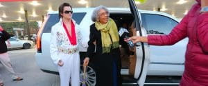 Elvis escorting Alyce Clark from her vehicle to buy her first scratch off ticket